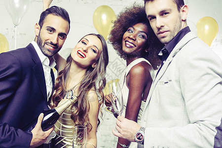在俱乐部聚会的人 庆祝和倒香槟的派对男人套装眼镜新年乐趣夫妻团体裙子女士庆典图片