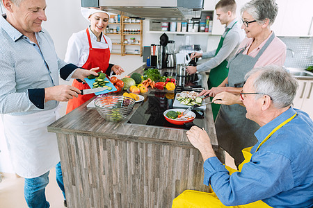 厨师向受训者展示在厨房做健康烹饪的秘密教学食物饮食蔬菜课程建议班级团体轮椅实习生图片