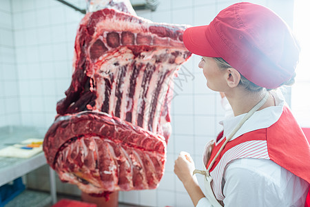 屠夫妇女检查肉片进行加工的肉类牛肉工业施工生产商业标志屠宰场食物工作工人图片