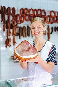 店员助理 在她的屠宰场里拿着火腿职业销售食物牛肉障碍营业员杂货售货员助手香肠图片