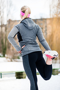 妇女在冬季日户外运动训练期间拉长时间;图片