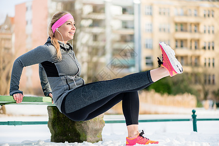 妇女为了冬季的体育活动而伸展四肢女士小路动机微笑运动乐趣闲暇健身步道耐力图片