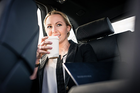 女商务人士在汽车里喝着咖啡图片