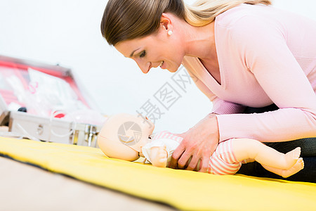 参加急救课程的妇女 在婴儿出生时恢复婴儿的活力d人员通风孩子玩具工作情况呼吸健身房帮助娃娃图片
