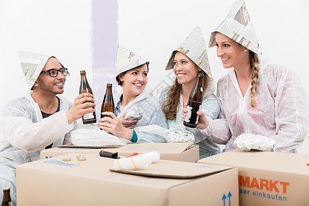 一群朋友穿着纸帽 享受着酒喝图片