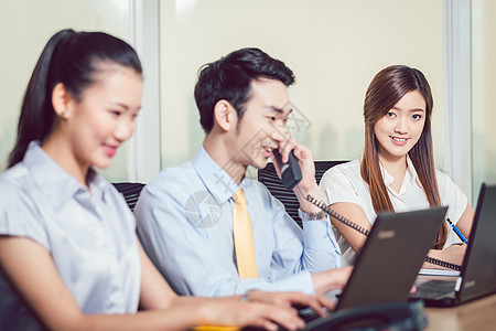 使用笔记本电脑和电话的商务人士团体人士职业生意男人微笑女性成人职场办公室图片