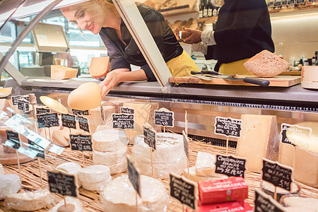 商店店员在超市展品中挑奶酪市场营业员文员熟食围裙女士店铺奉献推杆食物图片