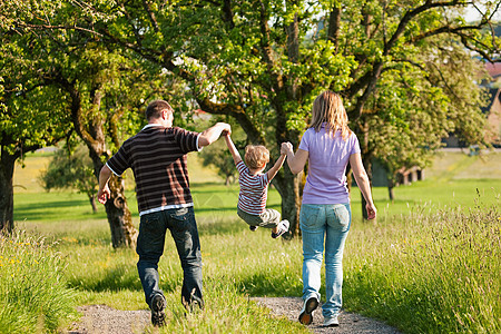 夏季家庭在户外散步儿子父母小路跑步男生男人娱乐丘陵孩子树木图片