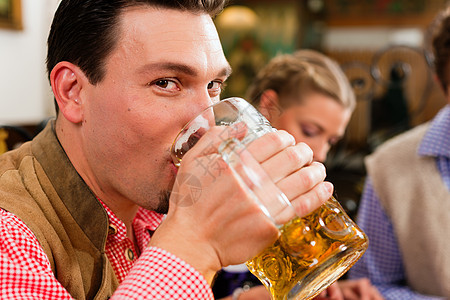 在巴伐利亚酒吧喝啤酒的人饮料少女装友谊传统皮裤微笑玻璃客栈团体成人图片