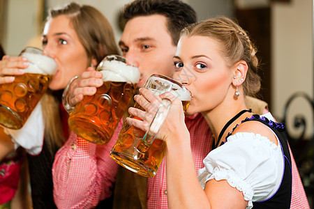 在巴伐利亚酒吧喝啤酒的人成人客栈女士男性传统朋友们眼镜微笑享受乐趣图片