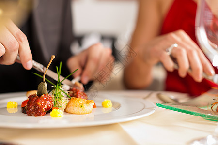 情侣在好餐厅吃饭喝着酒夫妻食物鞑靼庆典菜肴酒馆套装玻璃黑色红色图片