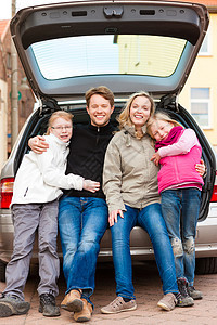 家庭在汽车旅行 在后面坐着爸爸男性孩子们妈妈姐妹车辆假期母亲男人街道图片