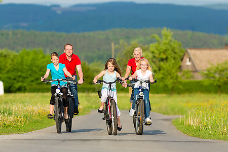 家庭有孩子在夏季骑自行车骑自行车男人孩子们旅行父亲晴天骑术妈妈阳光运动夫妻图片
