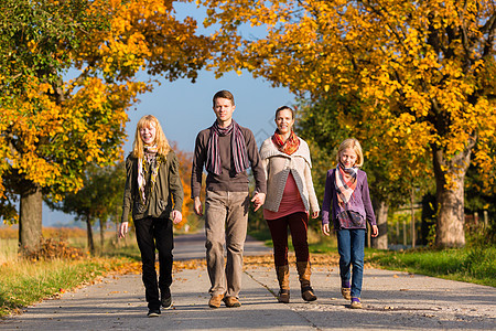 秋天家庭在多彩树木前行走幸福父亲女孩们女儿乐趣太阳姐妹母亲姐姐阳光图片