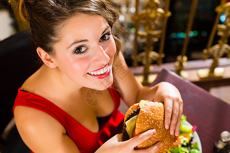 年青女子在美食餐厅吃汉堡面包餐桌女性庆典沙拉举止邀请函礼仪女士女孩图片