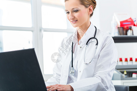 女医生在诊所的Pc上写作医院窗户医疗办公室女士职业卫生桌子保健劳动图片