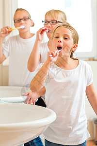 女孩在洗澡间刷牙治疗孩子们金发过夜女儿姐姐卫生眼镜孩子浴室图片