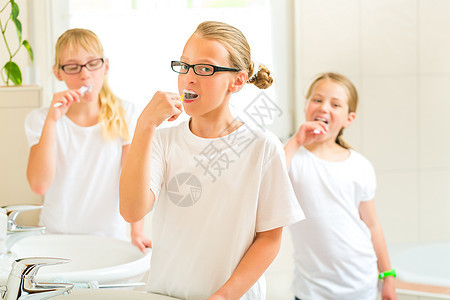 女孩在洗澡间刷牙脸盆女儿牙齿女儿们姐妹过夜姐姐喜悦访问孩子们图片