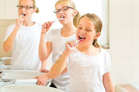 女孩在洗澡间刷牙脸盆喜悦友谊女儿们姐姐治疗访问孩子们配件朋友图片