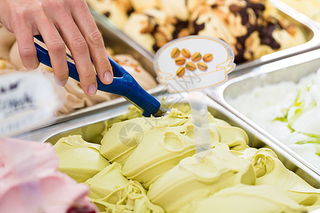 Parlor 有很多不同种类的冰淇淋客厅胡扯员工女士开心果展示锥体奶油柜台店铺图片
