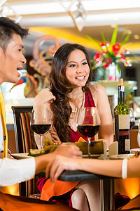 中国商务人士在优雅的餐厅吃晚饭午餐男人酒店用餐女性红色派对食物集团情侣图片