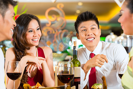 中国商务人士在优雅的餐厅吃晚饭商业红色午餐用餐朋友们集团男人瓶子庆典食物图片