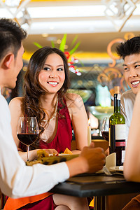 中国商务人士在优雅的餐厅吃晚饭瓶子食物用餐团体酒店商业红色派对桌子成人图片