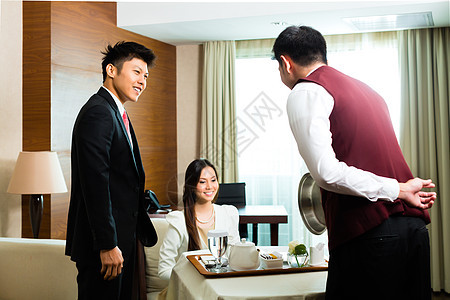 在旅馆套间供餐的亚洲中文房服务员图片