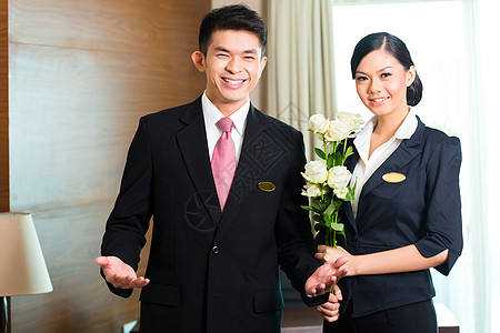 亚裔中国旅馆经理欢迎贵宾光临款待客人工作商业房间治疗套房导师职业花朵图片