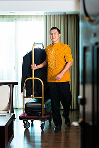 亚洲钟男孩拉箱子面包车的肖像成人行李服务职员搬运工旅馆微笑员工房间职业图片