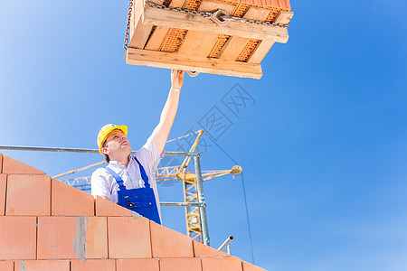 建筑工地工人加起重机的建筑房石头男人就业砖块男性调色板工匠石墙项目职业图片