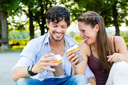 在城市公园的年轻夫妇 喝咖啡幸福享受旅游微笑楼梯咖啡游客杯子假期公园图片