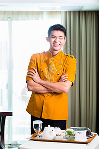 亚裔中华客房服务员 在旅馆套间供餐衬衫服务食物工作套房商业管家盘子送货房间图片