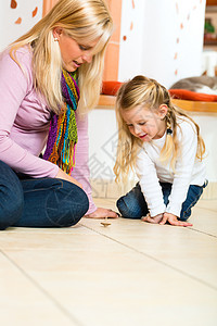 女孩玩木制玩具机玩具地面夫妻房地产父母生活旋转母亲乐趣处理图片