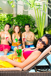 亚洲朋友在游泳池派对上度假聚会团体俱乐部躺椅比基尼游泳男人庆典朋友们太阳阳光图片