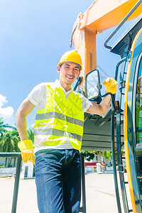 建筑工地上带有挖土机的亚洲建筑商图片