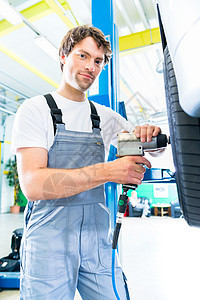 汽车车间的机械轮胎更换修理工运输工作男人店铺技术员职业服务车辆工具图片