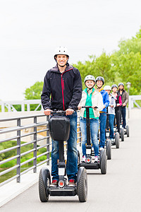 在观光旅游时驾驶Segway的旅游团体游客头盔安全电机城市指导旅行供电乐趣两轮车图片