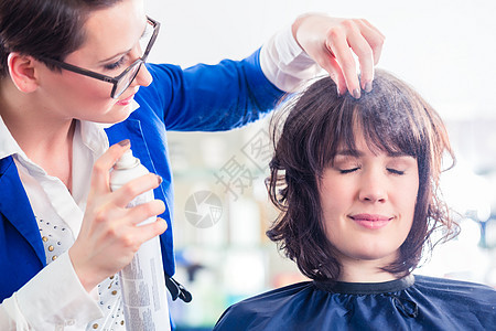 发发师在店里给女人理发工作造型女士发型职业女性店铺发胶造型师理发店图片