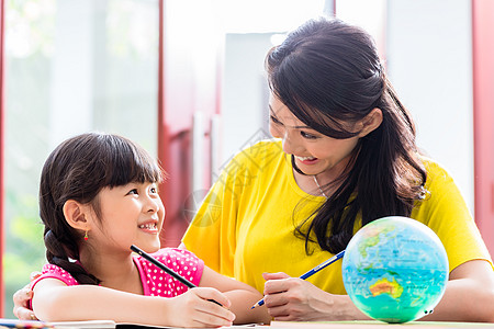 中华母亲与子女一起做学校功课写作女儿教学孩子地理女孩家庭作业妈妈学生桌子图片