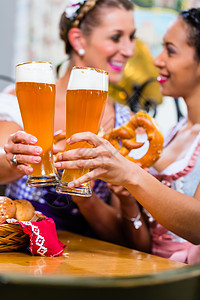 在巴伐利亚旅馆与Pretzel和Beer的女朋友啤酒酒吧传统女士少女装女性黑色朋友们客栈餐厅图片