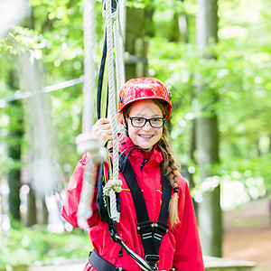 女孩在高绳道上忙碌弹簧绿色闲暇冒险孩子安全头盔风险绳索木头图片