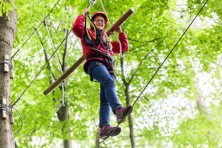 儿童在高绳绳课程中攀登平台高空挑战绳索女孩运动风险木头公园绿色闲暇图片