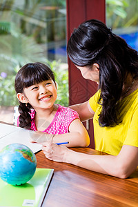 中华母亲与子女一起做学校功课写作女儿桌子地理教育孩子女孩学生妈妈家庭作业图片