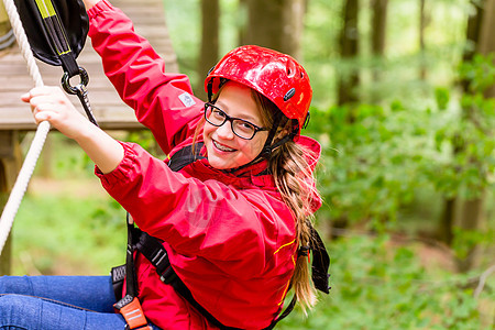 儿童在高绳绳课程中攀登平台头盔行动闲暇高空挑战公园森林女孩绳索冒险图片