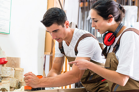 男女木匠团队一起工作木工作坊护耳制造商讨论工匠刨床橱柜体力劳动男人图片