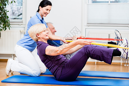 参加理疗的老年夫妇与Hula hoop一起锻炼治疗动机白银办公室呼啦圈理疗师疗法康复女士伙伴图片