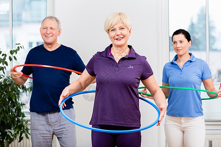 参加理疗的老年夫妇与Hula hoop一起锻炼白发肌肉体操治疗动机女士伙伴女性组织疗法图片