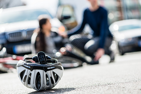 一个骑自行车头盔的贴紧 被击倒在地上图片