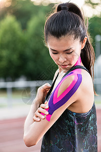 妇女用治疗性磁带在运动节的灰尘轨道上抽打妇女全能竞赛运动员比赛会场运动装女性田径地面赛跑者图片